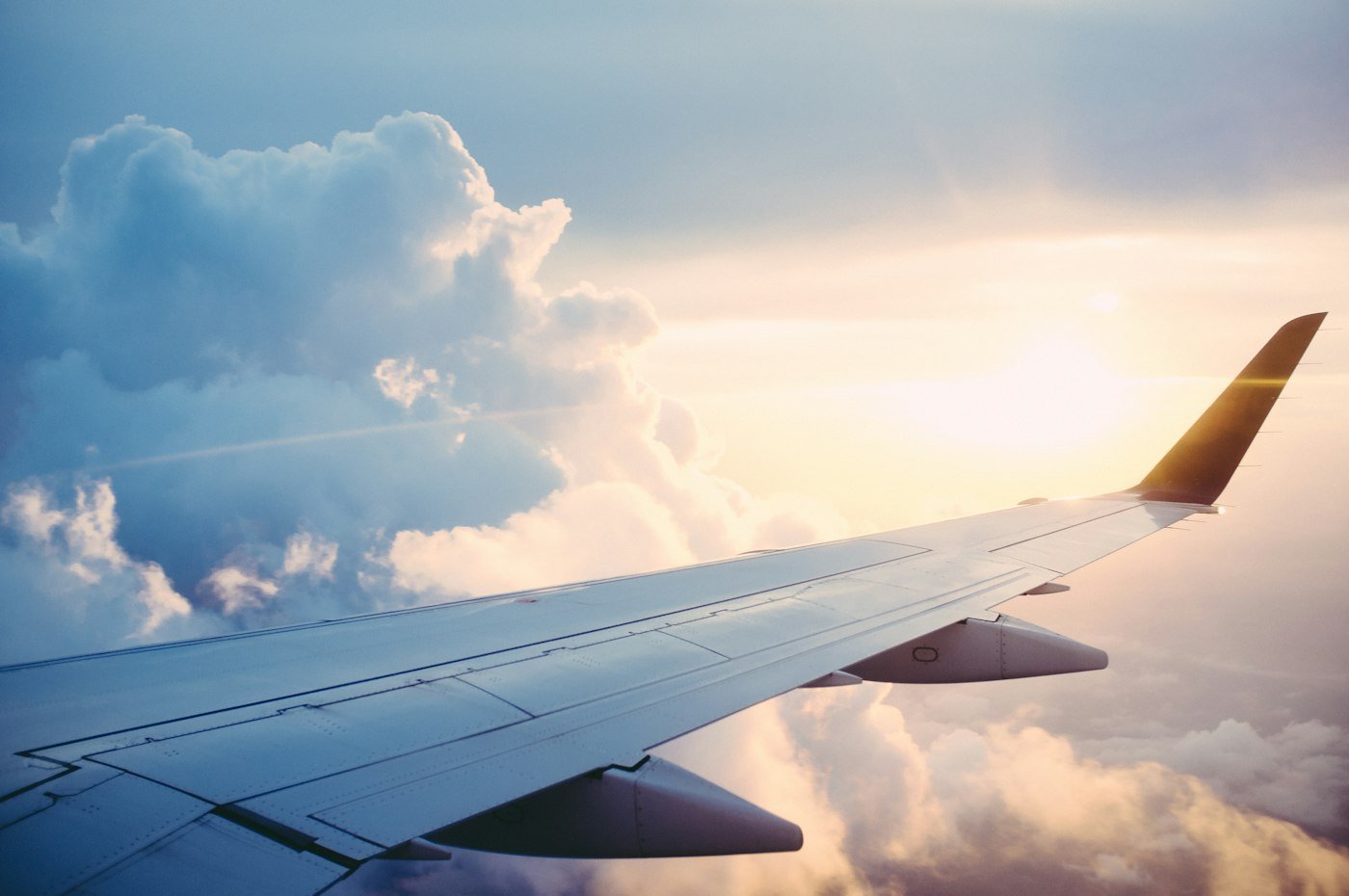 Aircraft wing above clouds at sunset